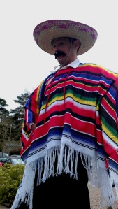 An actor dressed in traditional Mexican attire poses for a picture